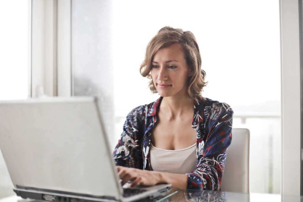 Lady at Computer Smugly Looking at her Home's Appreciate on a laptop